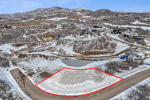 Snowy aerial view featuring property parcel outlined and a mountain view