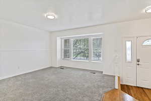 Foyer entrance featuring wood finished floors and wainscoting