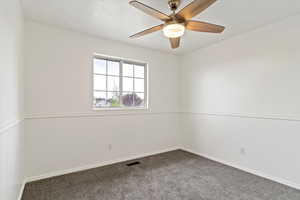 Empty room with carpet floors, a ceiling fan, and baseboards