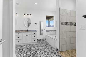 Bathroom with a bath, vanity, and tiled shower