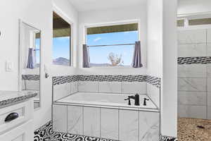 Bathroom with a garden tub, healthy amount of natural light, and a tile shower