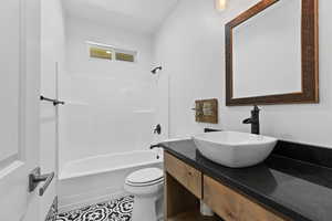 Bathroom with vanity, bathing tub / shower combination, and tile patterned floors