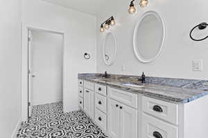 Full bathroom featuring double vanity and tile patterned flooring