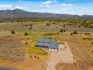Aerial view of property and surrounding area featuring a mountain backdrop