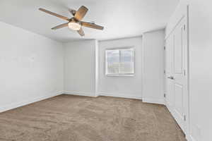 Unfurnished bedroom featuring carpet flooring, ceiling fan, and a textured ceiling