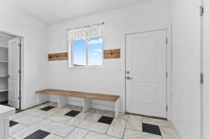 Mudroom featuring light marble finish flooring and baseboards