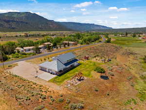 Aerial view of property and surrounding area with a mountain backdrop