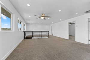 Carpeted spare room featuring ceiling fan and recessed lighting