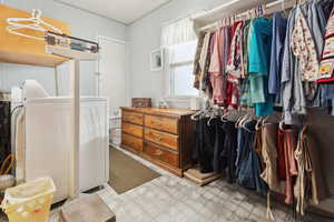 Walk in closet featuring light flooring and washer and dryer