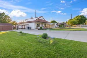 Rear view of property featuring a porch, driveway, and a chimney
