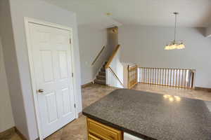 Kitchen with dark countertops, a chandelier, and pendant lighting