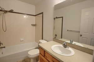 Bathroom featuring vanity, toilet, shower / tub combination, and tile patterned floors