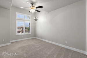 Unfurnished room with a ceiling fan, light colored carpet, baseboards, and a textured ceiling
