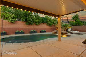 Pool at dusk featuring a patio area and a fenced backyard