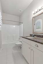 Full bath with vanity, bathtub / shower combination, toilet, and tile patterned floors