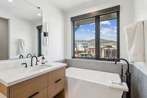 Primary Full bath with a freestanding bath, vanity, and recessed lighting