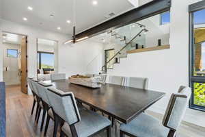 Dining room featuring stairs, light wood finished floors, plenty of natural light, recessed lighting, and baseboards