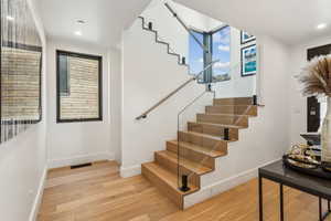 Staircase featuring wood finished floors, baseboards, and recessed lighting