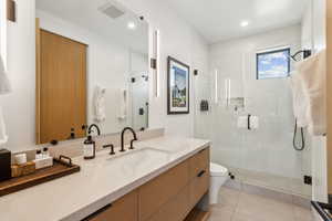 Full bathroom featuring vanity, toilet, a stall shower, tile patterned flooring, and recessed lighting