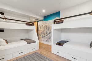 Bedroom with light wood-type flooring, baseboards, and recessed lighting