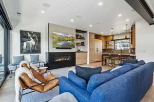 Living area with light wood-style floors, recessed lighting, and a fireplace