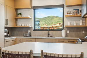 Kitchen featuring open shelves, a sink, light countertops, and a mountain view
