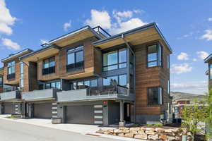 View of property featuring a garage and central AC unit