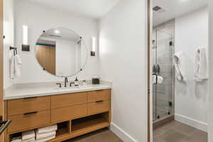 Bathroom featuring vanity, a shower stall, tile patterned floors, and baseboards