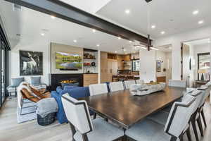 Dining area with light wood-style floors, a fireplace, and recessed lighting