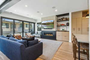Living area featuring light wood-style floors, a large fireplace, and recessed lighting