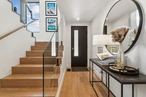 Foyer entrance featuring light wood-style flooring, stairs, baseboards, and recessed lighting