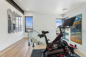 Exercise area with plenty of natural light, wood finished floors, baseboards, and recessed lighting