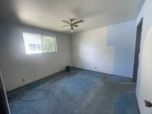 Carpeted spare room featuring a ceiling fan