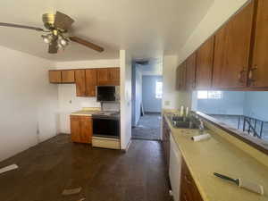 Kitchen featuring range with electric stovetop, a sink, brown cabinetry, and light countertops