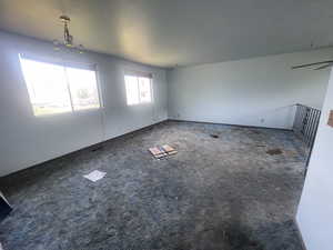 Empty room with carpet floors and a chandelier