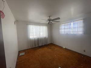 Spare room with healthy amount of natural light, carpet floors, and a ceiling fan