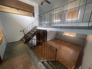 Stairway featuring healthy amount of natural light, a ceiling fan, and wood finished floors