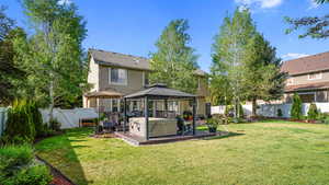 Back of property featuring a gazebo, stucco siding, and a hot tub