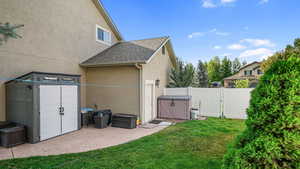 View of home's exterior with stucco siding, a gate, and a shingled roof