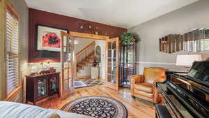 Living room featuring french doors, wood finished floors, and stairs