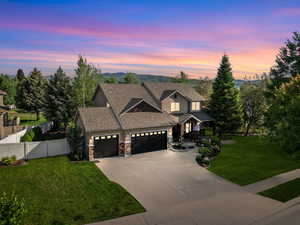 Craftsman-style house with a garage, stone siding, a shingled roof, and concrete driveway