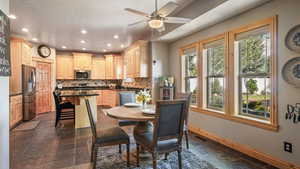 Dining space featuring stone tile floors, baseboards, recessed lighting, and a ceiling fan