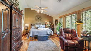 Bedroom featuring lofted ceiling, light wood-type flooring, and baseboards