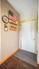 Entryway with stone tile floors, baseboards, and a textured ceiling