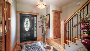 Entryway with stairway, baseboards, and wood finished floors