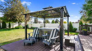Deck featuring a hot tub and a gazebo