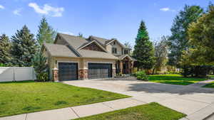Craftsman house with driveway, an attached garage, stucco siding, stone siding, and roof with shingles