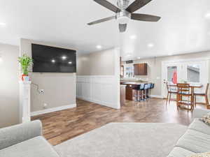 Living area with wood finished floors, a ceiling fan, and recessed lighting