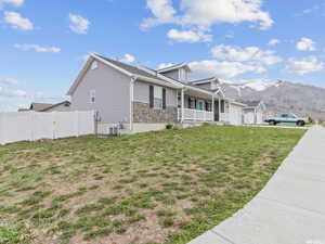 View of side of home featuring an attached garage, a porch, and a mountain view
