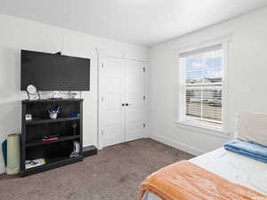 Carpeted bedroom with a closet and baseboards